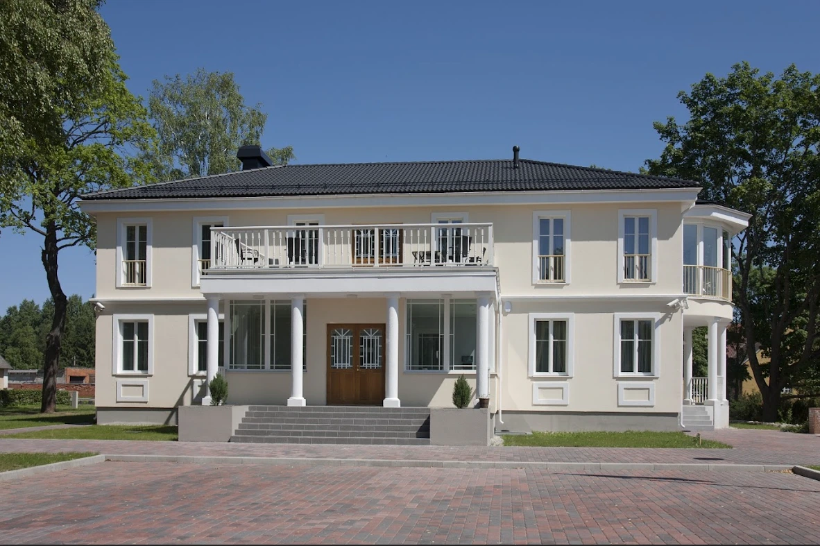 Tvåvånings villabyggnad i klassisk stil med balkong och trappa